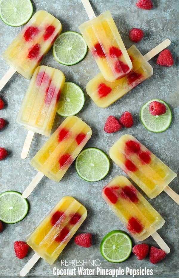  Hjemmelavet forfriskende kokosvand ananas Popsicles med hindbær og limesaft på en metaloverflade - BoulderLocavore.com