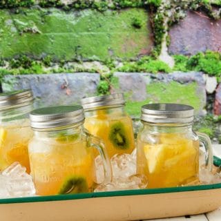 Light, refreshing Tropical Sangria in Mason jar drinking mugs with handles