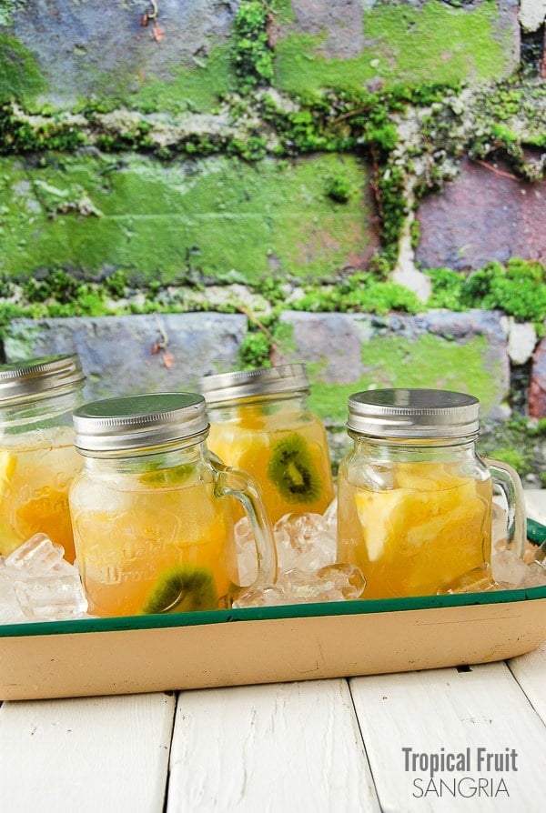 Light, refreshing Tropical Sangria in Mason jar drinking mugs with handles