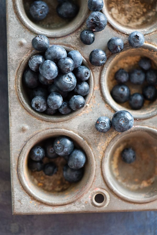 Fresh blueberries in a distressed vintage muffin tin 