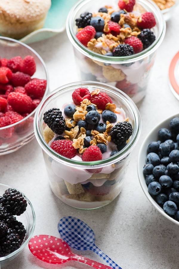 Glass jars of gluten-free Overnight Lemon Muffin Breakfast Trifles with fresh raspberries, blueberries