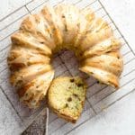 Gluten-Free Zucchini Chocolate Chip Bundt Cake with vintage cooling rack and ornate etched silver cake server