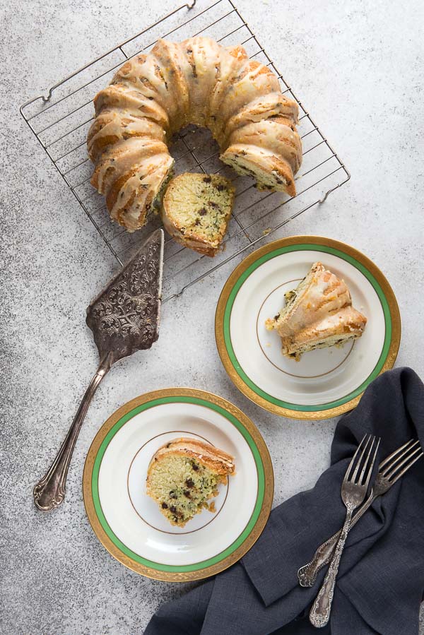 Sliced Gluten-Free Zucchini Chocolate Chip Bundt Cake with Orange Glaze on vintage Haviland china 