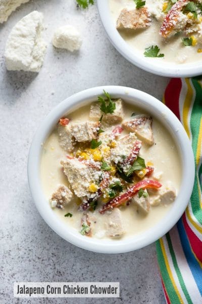 White bowl of Jalapeno Corn Chicken Chowder soup with cojito cheese and chopped cilantro