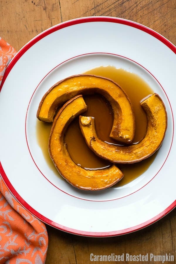Three sliced of Caramelized Roasted Pumpkin in a caramel cinnamon ginger sauce in an oversized white bowl with red trim