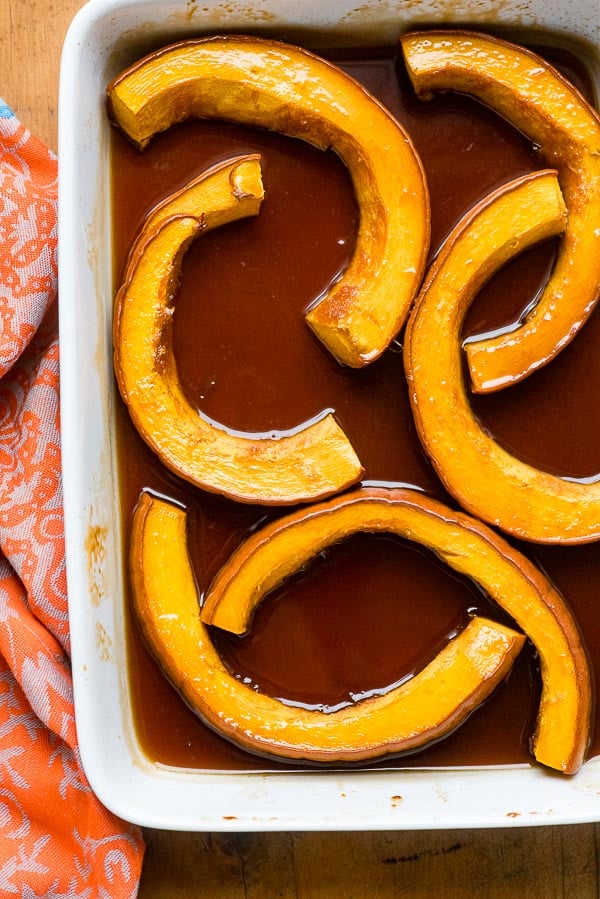 Sliced of fresh pumpkin in a white baking dish for Caramelized Roasted Pumpkin