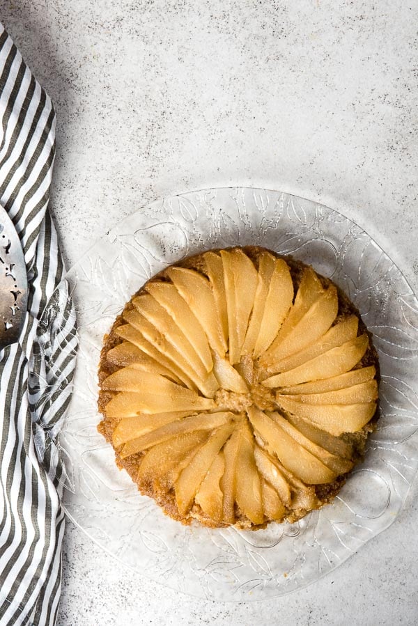 Freshly baked Caramelized Pear Upside Down Cake on a clear etched glass cake platter 