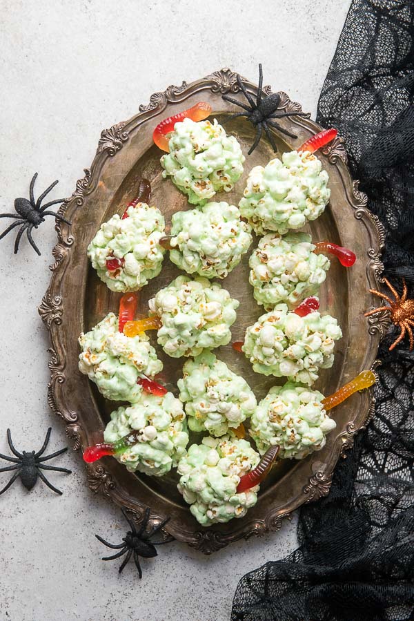 Ornate vintage silver tray of green Fast Easy Popcorn Balls for Halloween with gummy worms 