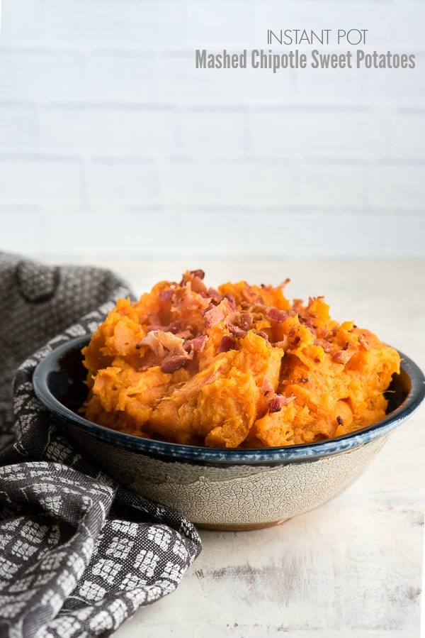 Creamy Instant Pot Mashed Chipotle Sweet Potaotes with Bacon crumbles in a gray glazed ceramic bowl