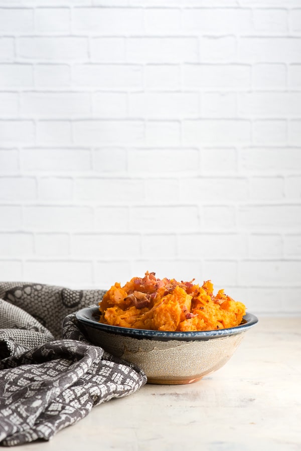 Bowl of Instant Post Mashed Chipotle Sweet Potatoes with Bacon crumbles in a ceramic bowl 