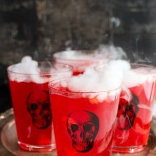 Spooky Slow Cooker Vampire Punch in skull glasses on an antique silver tray