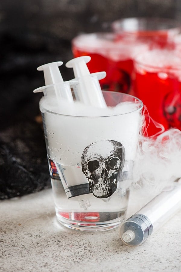 Skull glass of vodka with shot syringes 
