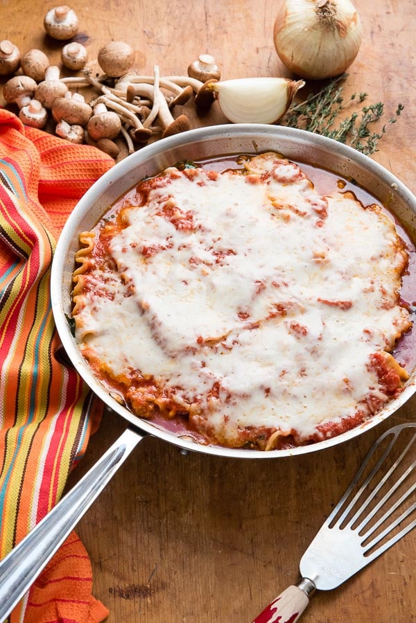 Spicy Sausage Skillet Lasagna with fresh mushrooms, onion wedge and thyme sprigs