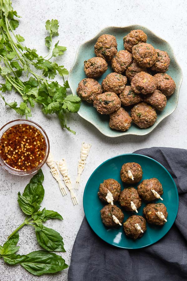 Two blue plates of gluten-free Thai Chicken Meatballs with fresh Sweet-Spicy Dipping Sauce