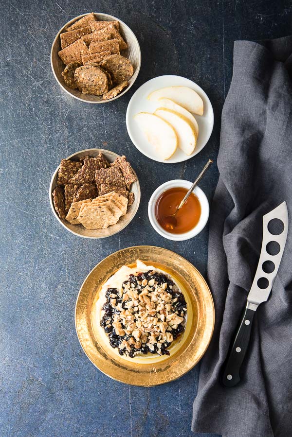 Blueberry Walnut Baked Brie with cheese knife, crackers, honey and pears