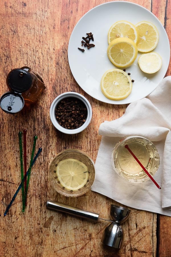 Glasgow Hot Toddy with cloves, lemon slice, colorful stirring sticks and cream colored linen napkin