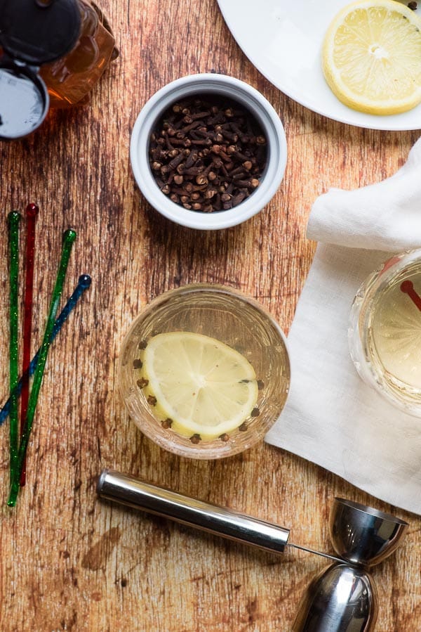 Glasgow Hot Toddy with cloves and lemon slice, stirring sticks and a linen napkin