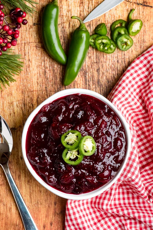 Spicy Jalapeno Cranberry Sauce with jalapeno slices, whole jalapenos, pine sprigs