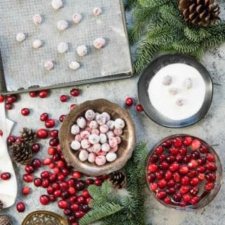 fresh and sugared cranberries in a silver bowl and on a baking sheet