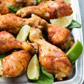 Instant Pot Smoked Paprika & Garlic Chicken Legs with lime wedges on a pewter platter