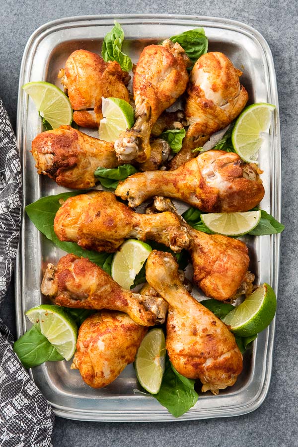 Instant Pot Smoked Paprika & Garlic Chicken Legs with lime wedges on a pewter platter