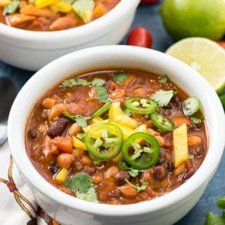 4 Bean Instant Pot Chili (vegan) with jalapeno slices, diced yellow bell pepper in a white bowl