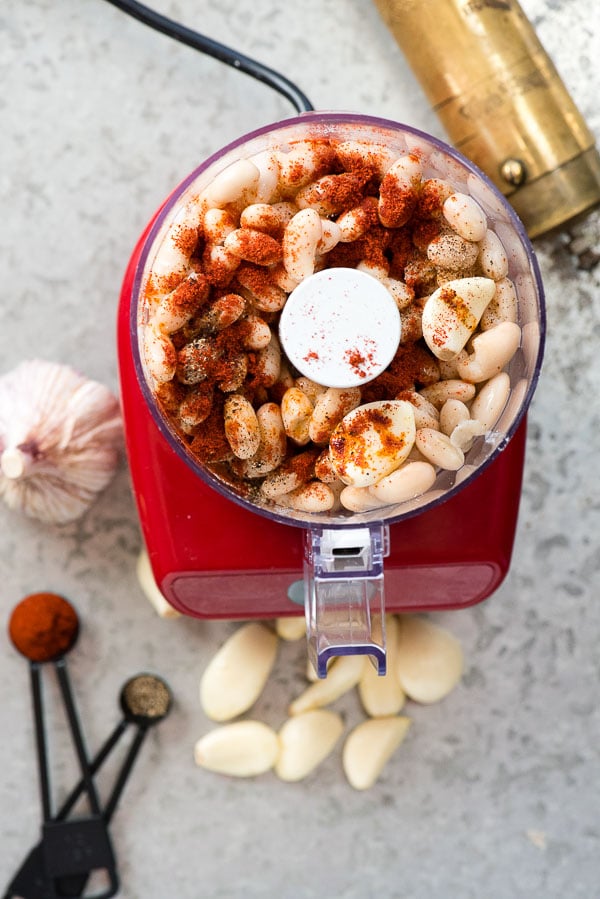 Cannellini beans, garlic, smoked paprika, black pepper and ingredients for 5-Minute Smoked Paprika Garlic Bean Dip in a mini chopper