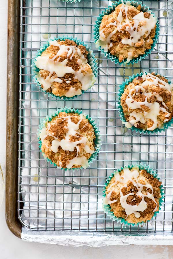 Freshly baked Coffee Cake Muffins with fresh orange glaze on a cooling rack