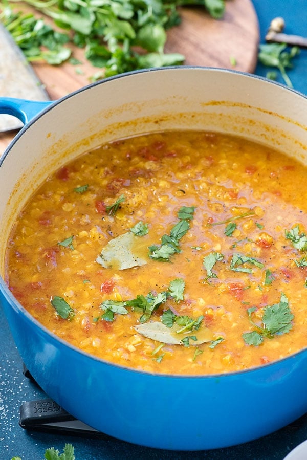 French-blue enamel pot of Curried Red Lentil Soup with torn cilantro leaves