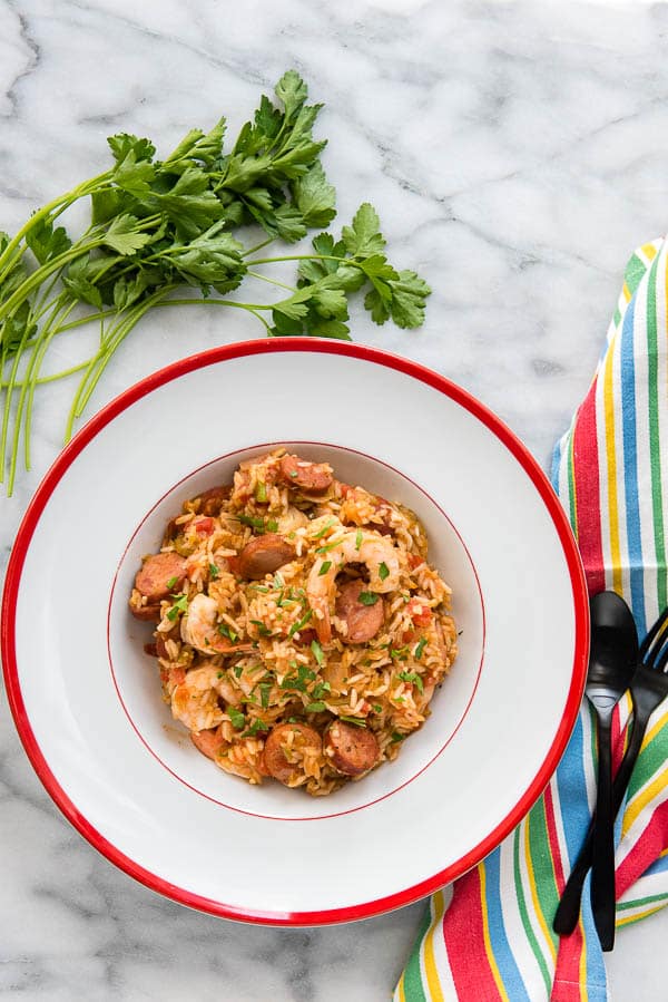 Spicy Instant Pot Jambalaya with Italian parsley in white bistro bowl with red rim