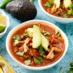 Instant Pot Chicken Taco Soup in white bowls with avocado slices, torn cilantro leaves, jalapeno pepper