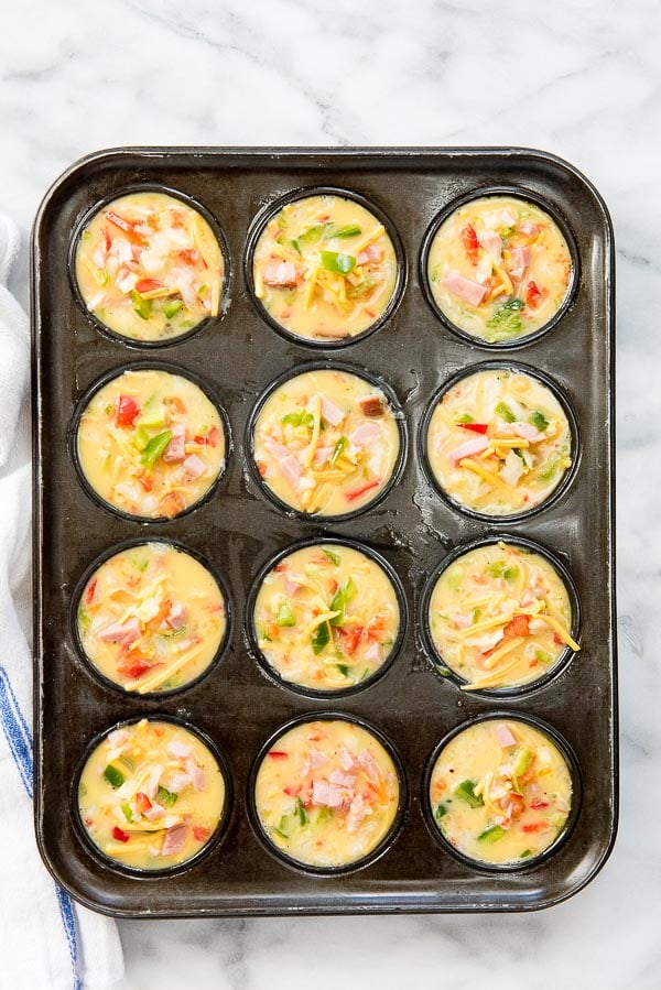 Muffin Tin eggs with vegetables and cheese before baking