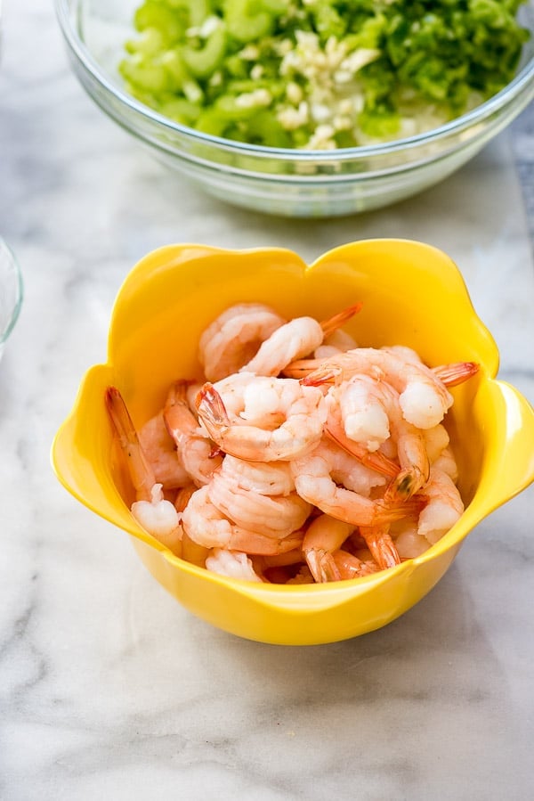 Shrimp in a yellow colander on marble surface