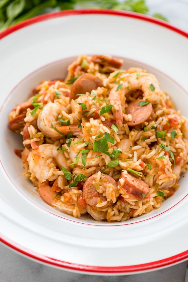 Instant Pot Jambalaya with torn Italian parsley in large white bowl