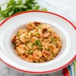 Spicy Instant Pot Jambalaya in white bistro bowl wtih red rim and Italian parsley