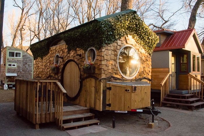 Sunrise at ivy-covered shingled The Hobbit House Tiny House at WeeCasa Tiny House Resort