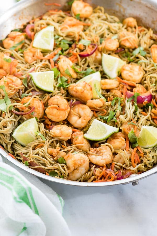 Dragon Shrimp Noodles with lime wedges and green striped towel