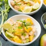 Instant Pot Mango Chicken with cilantro, scallions and lime wedges on rice