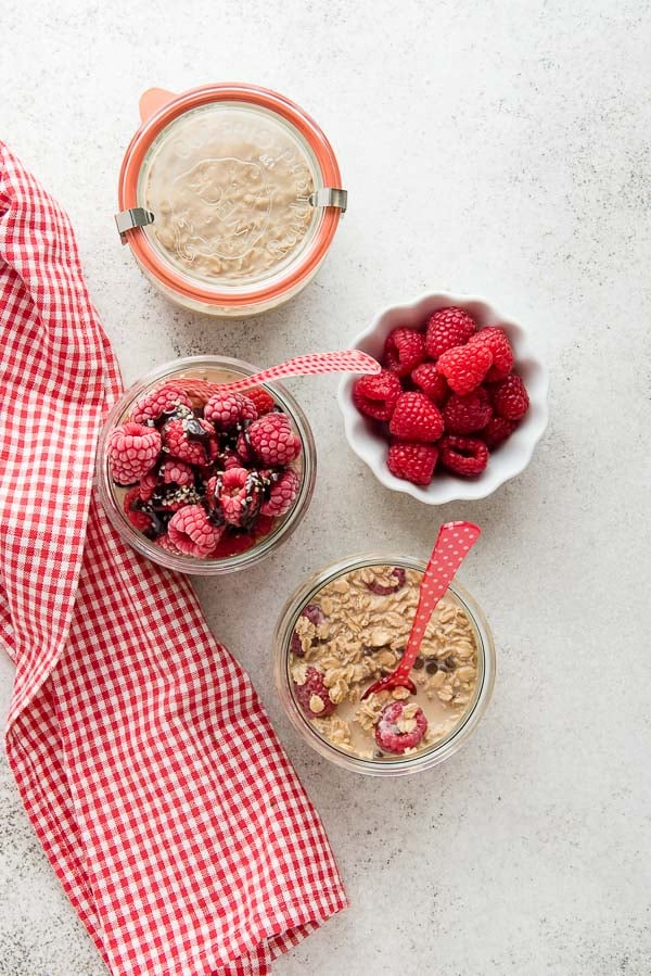 Raspberry Mocha French Vanilla Overnight Oats in tulip canning jars with a red and white checked towel