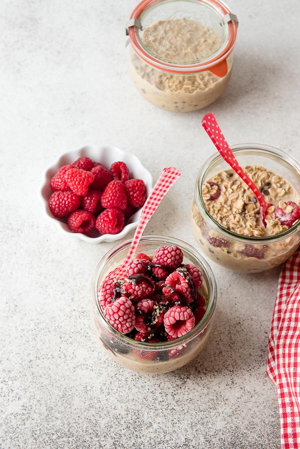 Raspberry Mocha French Vanilla Overnight Oats with fresh raspberries and red and white gingham spoons