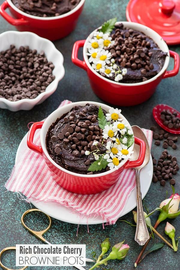 Rich Chocolate Cherry Brownie Pots in mini red cocottes with edible flower and mini chocolate chips on top