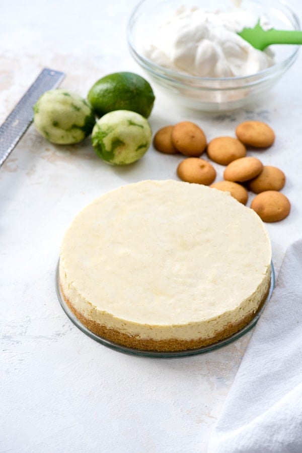 Instant Pot Lime Cheesecake with gluten-free vanilla wafer crust, zested limes, microplane and bowl of whipped cream