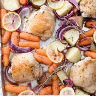 Sheet Pan Lemon Rosemary Chicken Thighs with cooked potatoes, carrots, onions and lemon slices