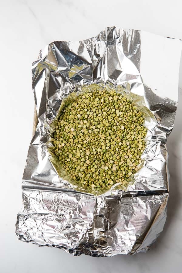 Foil over a frozen pie crust filled with split peas for blind baking