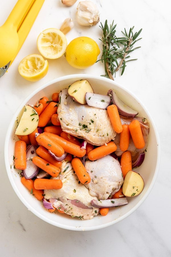chicken thighs and vegetables in a bowl with marinade