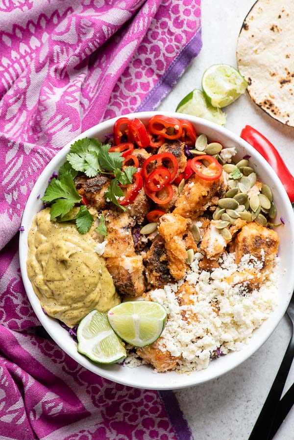 overhead view of Baja Fish Taco Bowl with colorful ingredients and a purple kitchen towel