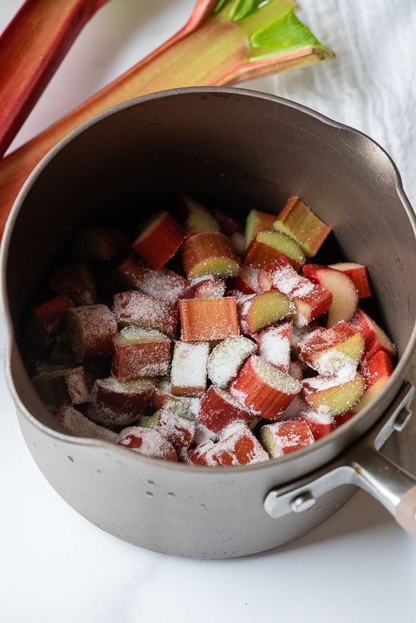 Sliced fresh rhubarb with sugar in a taupe saucepan