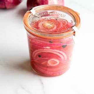Batch of Quick Pickled Red Onions recipe in a glass canning jar