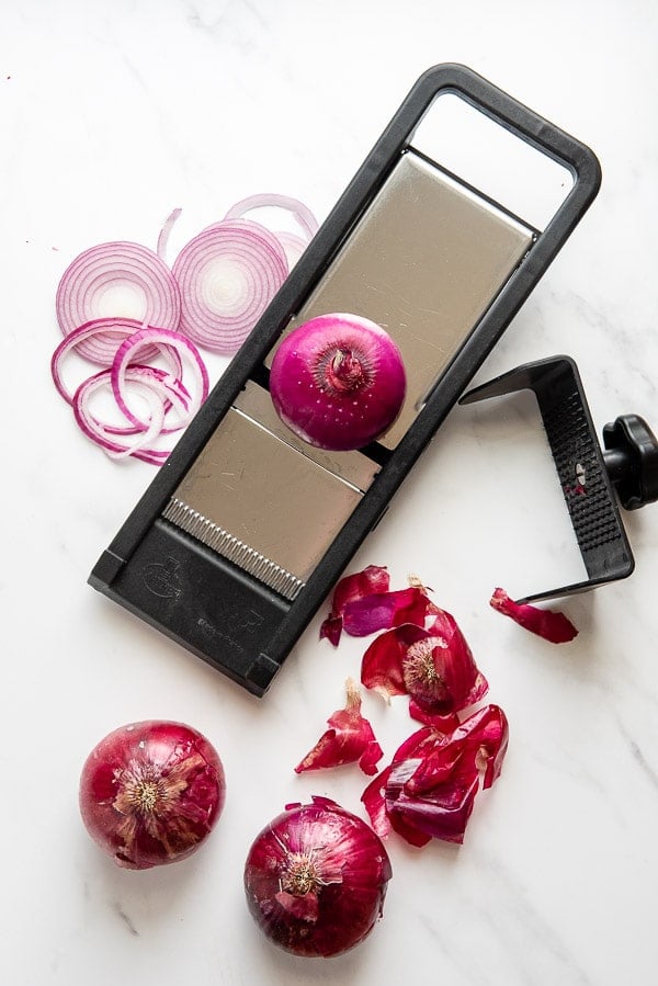 slicing red onions with a mandoline