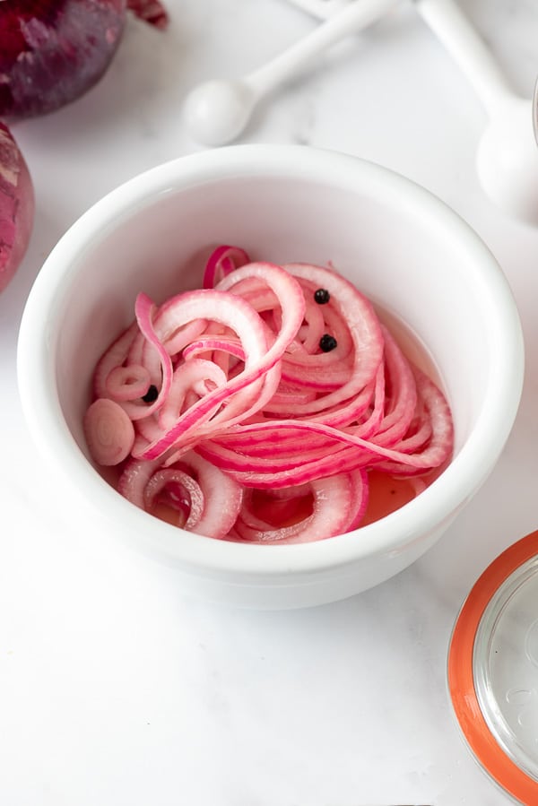 quick pickled red onions in a white ceramic bowl